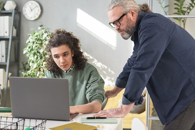 Educator guiding a student through a lesson on a laptop